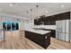 Stylish kitchen featuring stainless steel appliances, a central island, hardwood floors, and sliding glass doors to the patio at 816 Lilyquist Way, Wake Forest, NC 27587