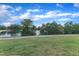 Scenic view of the lake with green trees and bushes under a blue sky with white clouds at 816 Lilyquist Way, Wake Forest, NC 27587