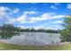 Picturesque lake view surrounded by lush trees under a bright, cloudy sky at 816 Lilyquist Way, Wake Forest, NC 27587