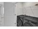 Modern laundry room with sleek, dark front-loading washer and dryer and wire shelving at 816 Lilyquist Way, Wake Forest, NC 27587