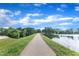 Paved walkway near a lake with trees reflecting in the water on a sunny day at 816 Lilyquist Way, Wake Forest, NC 27587