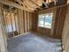 Unfinished bedroom shows framed construction, exposed beams, and window for natural light at 82 Laramie Ln, Selma, NC 27576