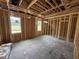Unfinished bedroom shows framed construction, exposed beams, with several windows for natural light at 82 Laramie Ln, Selma, NC 27576