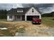 New home under construction, featuring a black roof, covered porch, and an attached two-car garage at 82 Laramie Ln, Selma, NC 27576