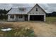 New home construction showing facade, covered porch, and two car garage on a partly cloudy day at 82 Laramie Ln, Selma, NC 27576