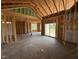Unfinished living room featuring vaulted ceilings and sliding glass door leading to the backyard at 82 Laramie Ln, Selma, NC 27576