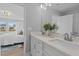 Well-lit bathroom with double sinks, quartz countertop, leading to a glimpse into the connected bedroom at 825 Kensley Grove Ln # 19, Fuquay Varina, NC 27526