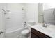 Well-lit bathroom features a shower-tub combo with sleek white fixtures and a dark wood vanity at 826 Downfield Ln, Fuquay Varina, NC 27526