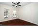Bedroom with hardwood floors, ceiling fan, and windows providing natural light, creating a cozy space at 826 Downfield Ln, Fuquay Varina, NC 27526