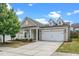 Charming home featuring a two-car garage, beige siding, manicured lawn, and well-maintained landscaping at 826 Downfield Ln, Fuquay Varina, NC 27526