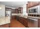 Stylish kitchen featuring stainless steel appliances, granite countertops, and rich wood cabinetry at 826 Downfield Ln, Fuquay Varina, NC 27526