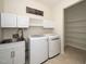 Convenient laundry room with modern washer and dryer, built-in cabinets, shelving, and utility sink at 826 Downfield Ln, Fuquay Varina, NC 27526