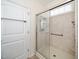 Bathroom shower with glass doors, grab bars, and tiled walls at 826 Downfield Ln, Fuquay Varina, NC 27526