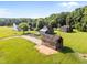 Aerial view of the farmhouse, surrounding buildings, and mature trees on a sprawling lawn at 8365 Aaron Creek Church Rd, Oxford, NC 27565