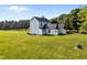 Rear view of a white two-story home on a lush green lawn with mature trees at 8365 Aaron Creek Church Rd, Oxford, NC 27565