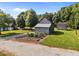 Exterior view of barns with an adjacent fenced garden, complemented by the surrounding greenery and landscape at 8365 Aaron Creek Church Rd, Oxford, NC 27565