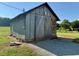 Exterior shot of a weathered barn with wide wooden doors, featuring durable stone foundation at 8365 Aaron Creek Church Rd, Oxford, NC 27565