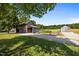 Exterior view of the property's barns with gravel drive, garden, and green lawn, showing outbuildings and landscaping at 8365 Aaron Creek Church Rd, Oxford, NC 27565