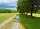 Gravel driveway leading to a picturesque property amidst a serene landscape at 8365 Aaron Creek Church Rd, Oxford, NC 27565