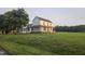 Two-story farmhouse featuring a covered porch, expansive yard, and lush green landscape at 8365 Aaron Creek Church Rd, Oxford, NC 27565
