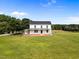 Classic two-story white farmhouse with a welcoming front porch and expansive lawn, bathed in sunlight at 8365 Aaron Creek Church Rd, Oxford, NC 27565