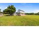 Quaint two-story farmhouse with a covered front porch, complemented by lush greenery and a spacious yard at 8365 Aaron Creek Church Rd, Oxford, NC 27565