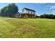 Charming two-story farmhouse with a covered front porch surrounded by expansive green lawn at 8365 Aaron Creek Church Rd, Oxford, NC 27565