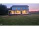 Beautiful two-story home with dark framed windows and a charming covered porch in the evening light at 8365 Aaron Creek Church Rd, Oxford, NC 27565