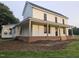 Charming two-story farmhouse with a covered front porch featuring wooden columns and a brick foundation at 8365 Aaron Creek Church Rd, Oxford, NC 27565