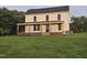 Two-story farmhouse with covered front porch and black framed windows surrounded by a lush green lawn at 8365 Aaron Creek Church Rd, Oxford, NC 27565