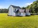 Back exterior view showcasing a two-story farmhouse, with original chimneys, plus multiple out buildings at 8365 Aaron Creek Church Rd, Oxford, NC 27565