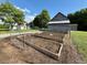 Raised garden beds in a homestead fenced area, featuring a barn in the background at 8365 Aaron Creek Church Rd, Oxford, NC 27565