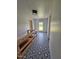 Hallway with black and white patterned tile floors, wood accent railing, and bright window at 8365 Aaron Creek Church Rd, Oxford, NC 27565