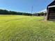 Expansive green field with outbuildings with mature trees creating a park-like setting at 8365 Aaron Creek Church Rd, Oxford, NC 27565