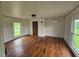 Bright living room with original hardwood floors, large window, and mini split system at 8365 Aaron Creek Church Rd, Oxford, NC 27565