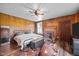 This is a main bedroom that features wood paneling, fireplace, ceiling fan, and beautiful hardwood floors at 8365 Aaron Creek Church Rd, Oxford, NC 27565