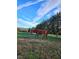Pastoral view showcasing a horse grazing in a lush green field under a vibrant sky at 8365 Aaron Creek Church Rd, Oxford, NC 27565