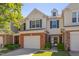 Charming two-story townhome with a brick-accented garage and manicured landscaping at 8404 Saltwood Pl, Raleigh, NC 27617