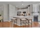 Bright kitchen with a white island, seating, stainless steel appliances, and fireplace at 8404 Saltwood Pl, Raleigh, NC 27617