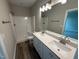 Bathroom with double sink vanity, bright lights, shower, and hardwood style flooring at 90 Brookhaven Dr, Spring Hope, NC 27882