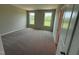 Spacious bedroom with neutral walls, carpet flooring, and a view of the open backyard at 90 Brookhaven Dr, Spring Hope, NC 27882