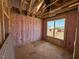 Unfinished bedroom with insulation and a window, showcasing the potential for customization at 90 Brookhaven Dr, Spring Hope, NC 27882