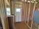 Unfinished entryway displaying exposed insulation, framing, and electrical components at 90 Brookhaven Dr, Spring Hope, NC 27882