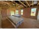 Unfinished living room with exposed beams, insulation, and ample natural light from multiple windows at 90 Brookhaven Dr, Spring Hope, NC 27882