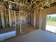 Unfinished living room with exposed beams, insulation, and sliding glass doors to the exterior at 90 Brookhaven Dr, Spring Hope, NC 27882