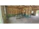 Unfinished interior with stud walls, rough-ins, and staircase to the second floor at 91 Caspian Ct, Lillington, NC 27546