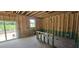Unfinished interior with stud walls, sliding glass doors opening to the yard, and a window at 91 Caspian Ct, Lillington, NC 27546