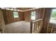 Upstairs unfinished area with stud walls, windows, and staircase access at 91 Caspian Ct, Lillington, NC 27546