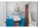 Bright bathroom featuring blue cabinets, a classic sink, and a shower with a patterned curtain at 940 Hill St, Rocky Mount, NC 27801