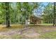 Mature trees and shrubs accent the backyard, with a view of the exterior of the home at 9509 Greenfield Dr, Raleigh, NC 27615